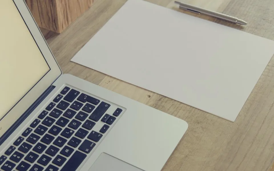 Computadora portátil y documentos sobre un escritorio de madera
